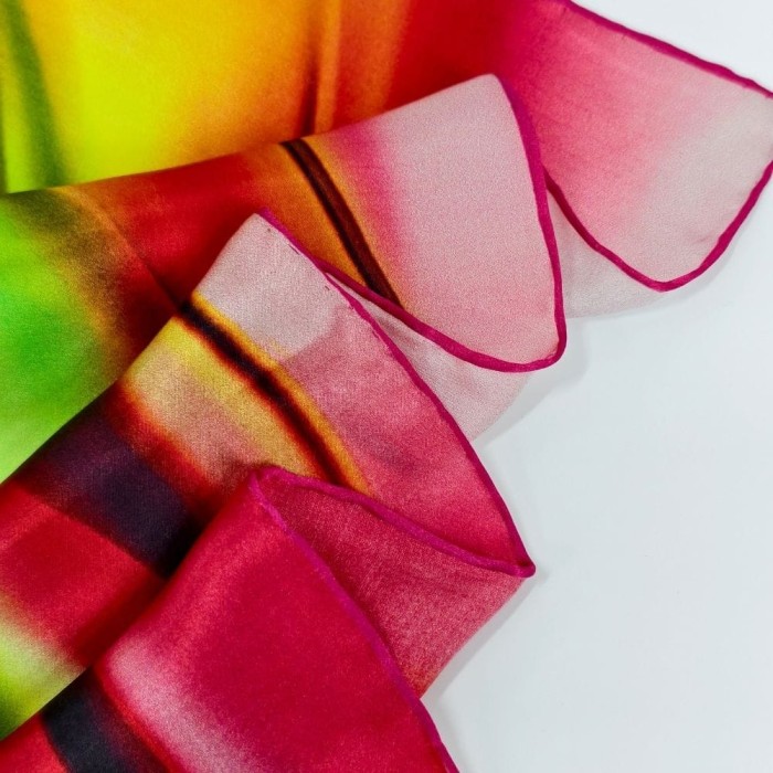 Detal ręcznie rolowanych brzegów chusty jedwabnej Summer Flame w odcieniach różu, czerwieni i żółci