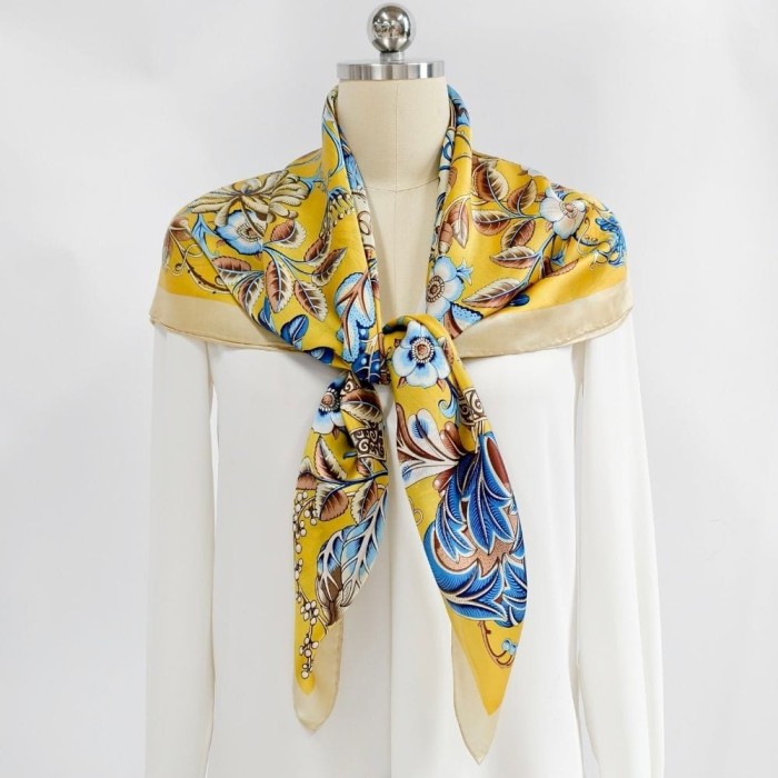 Jedwabna chusta Golden Botany zawiązana na manekinie jako elegancki dodatek do białej stylizacji